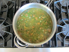 Broth covering vegetables in a stockpot.