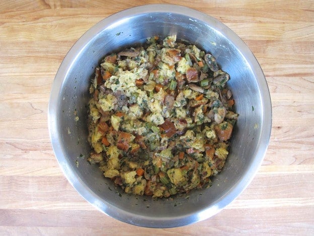 Challah cubes combined in a bowl with vegetables.