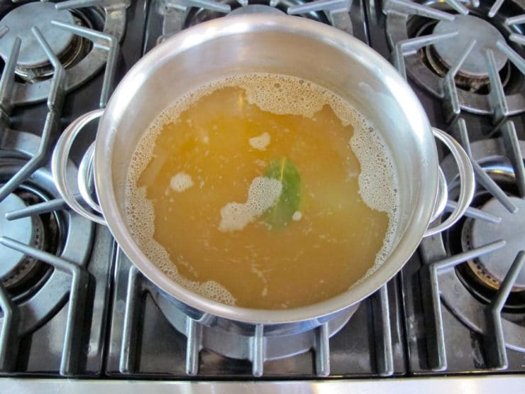 Chicken stock simmering in a stockpot.