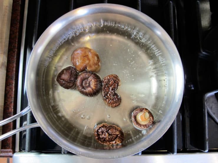 Dried mushrooms in a saucepan of water.