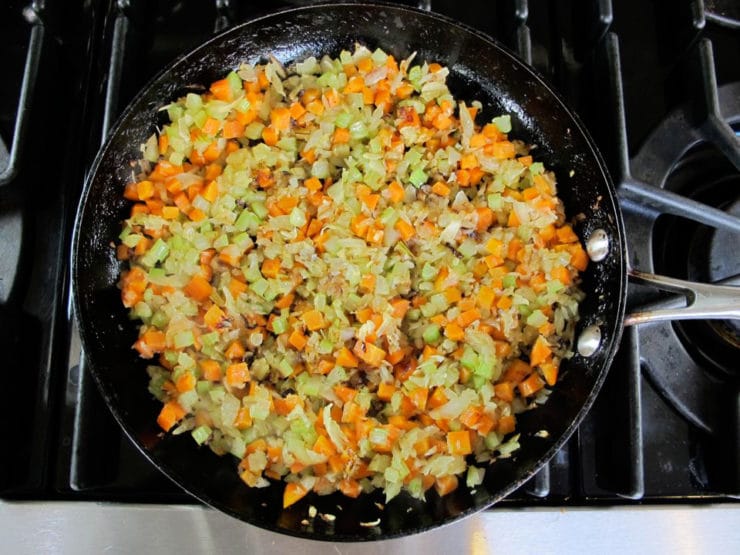 Diced carrots and celery added to a skillet.