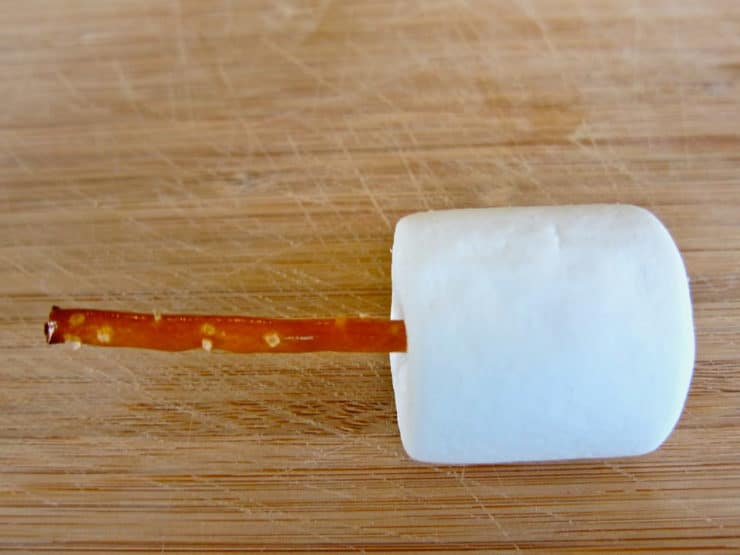 Large marshmallow with pretzel stick stuck in.