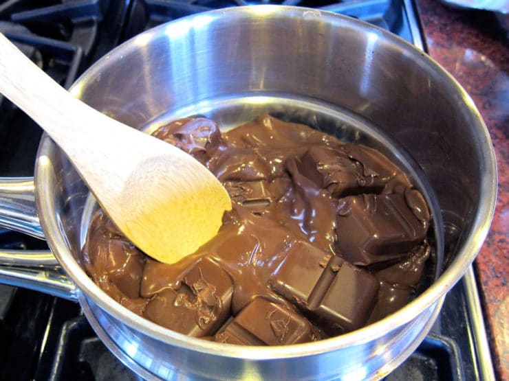 Melting chocolate in a double boiler with wooden spoon.