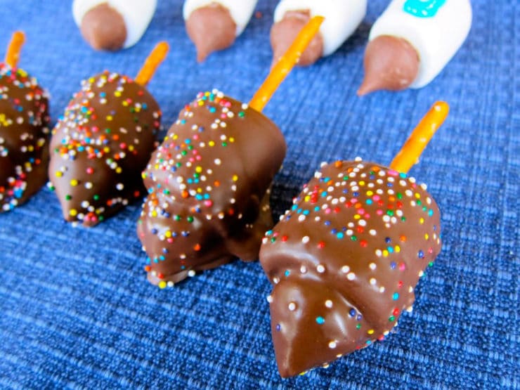 Candy dreidels close on chocolate dipped with sprinkles.