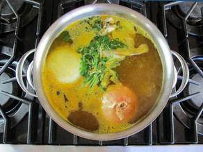Turmeric and cilantro added to chicken in pot.
