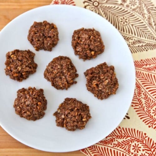 Image of no-bake Missouri Cookies with oats on a white plate on top of a place mat.