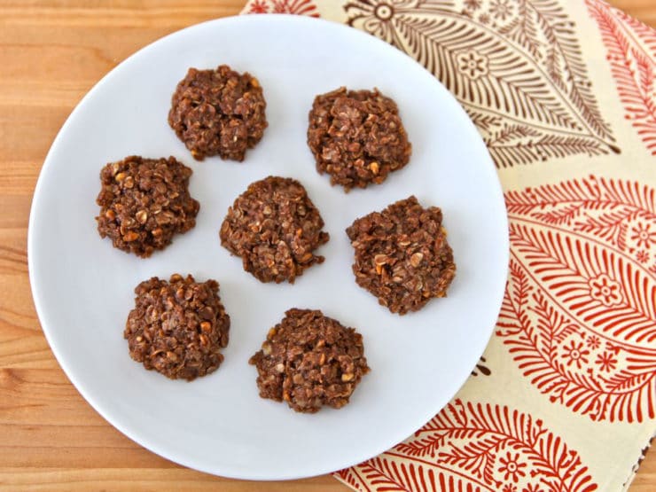 Image of no-bake Missouri Cookies with oats on a white plate on top of a place mat.