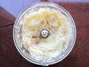 Potatoes grated in a food processor.