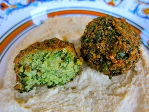 Herb green falafel balls on hummus.