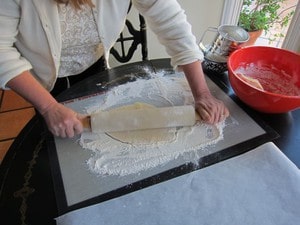 Rolling out dough on a floured surface.