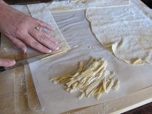 Cutting dried dough into strips.