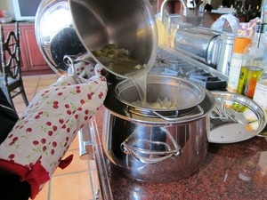 Straining broth into a clean pot.