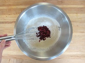Mixing pomegranate arils into flour.