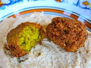 Yellow turmeric falafel balls on hummus.