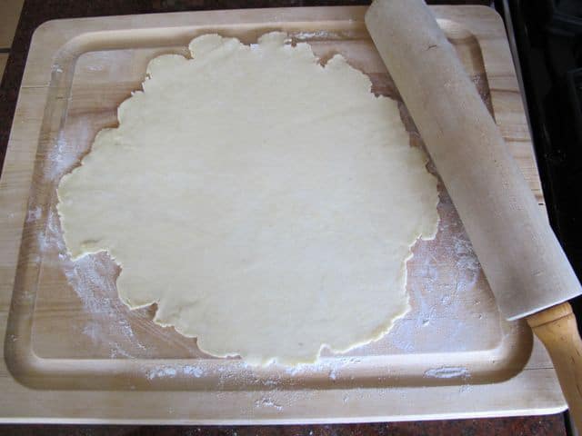 Rolling out rugelach dough into a large circle.