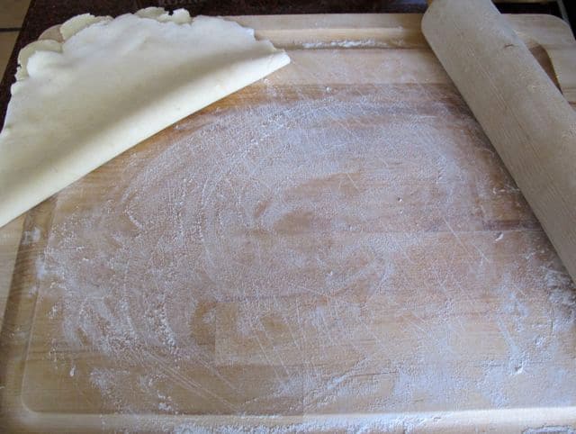 Rolling dough up to add more flour underneath.