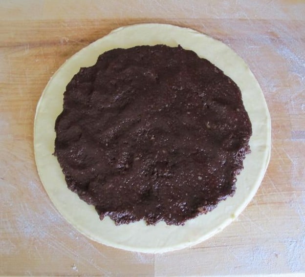 Rugelach filling spread on dough circle.