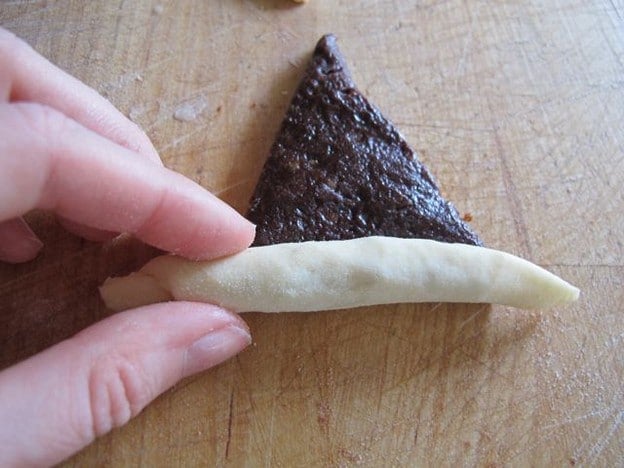 Rolling rugelach from wide end.