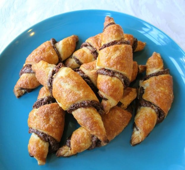 Rugelach crescent filled baked confection on a Blue plate.