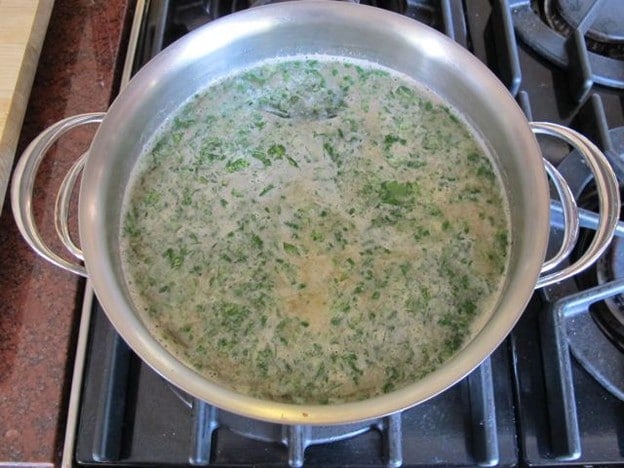 Broth and vegetables simmering in a stockpot.