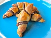 Rugelach crescent filled baked confection on a Blue plate.