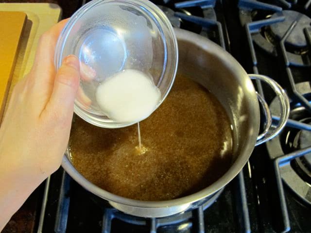 Adding a cornstarch slurry to pan drippings.