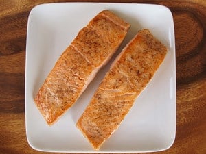 Seared salmon fillets on a plate.