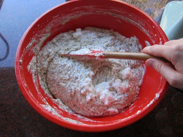 Folding whipped egg whites into cake batter.