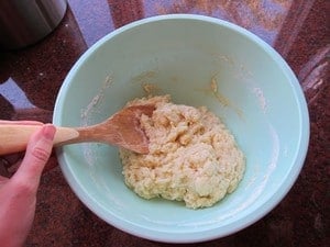 Stirring dough with a wood spoon.