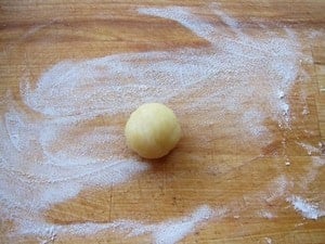 Walnut size dough ball on a cutting board.
