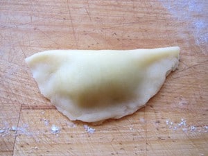 Dough circle folded in half with filling.