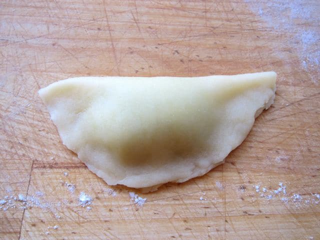 Dough circle folded in half with filling.