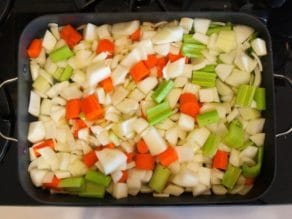 Onions, carrots and celery chopped in roasting pan on stovetop.