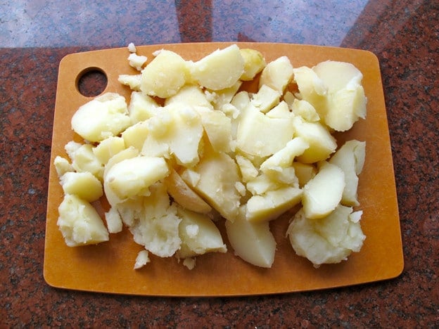 Smashed potatoes on a cutting board.