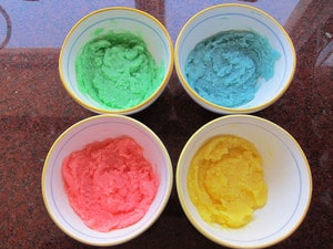 Dough in four small bowls in four colors.