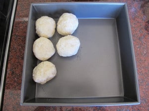 Cooked potato balls in a dish.