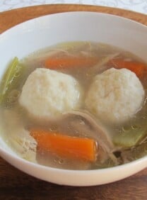 A bowl of Chicken Soup with Matzah Balls, turnip, and carrots