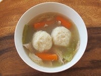 Top view of a Chicken Soup bowl with Matzah Balls, turnip, and carrots