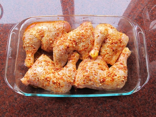 Seasoned oil spread over chicken quarters.