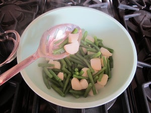 Removing vegetables from a pot with a slotted spoon.