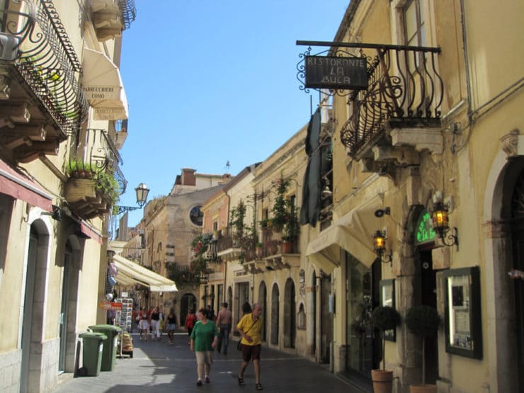 Pedestrian street in Taormina, Italy with tourists.