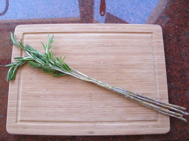 Pulling leaves off rosemary stems for skewers.