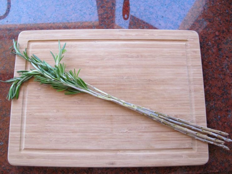 Pulling leaves off rosemary stems for skewers.
