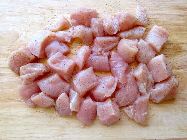 Cubed chicken on a cutting board.