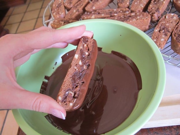 Dipping cookies into melted chocolate.
