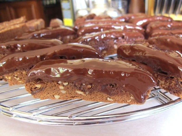 Triple Chocolate Almond Mandelbrot dipped on a chocolate on a cooling rack for baking