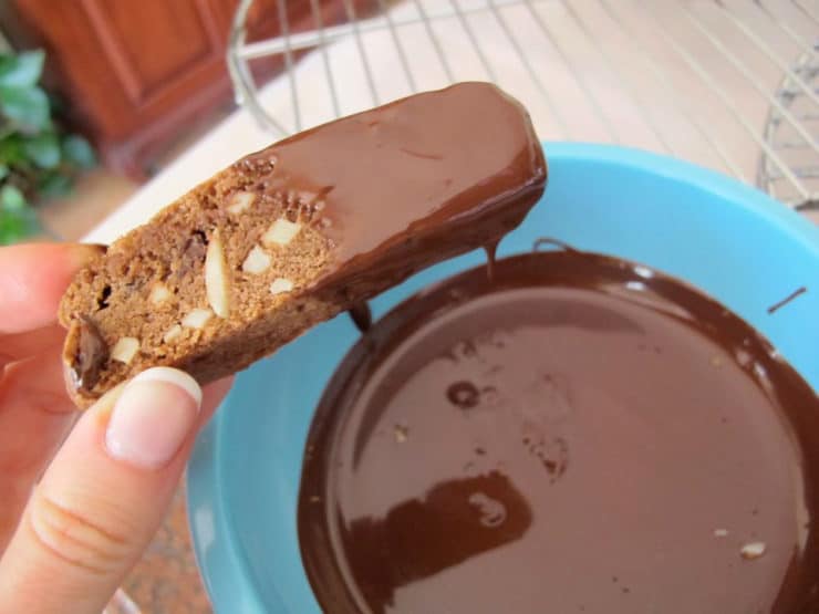 Dipping cookies into melted chocolate.