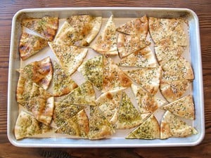 Pita triangles on an oiled baking sheet.