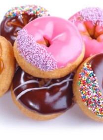 Pilot of colorful frosted doughnuts in various flavors on a white background.