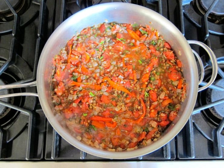 Vegetables and lentils simmering in a saucepan.